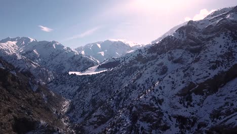 Fliegen-Sie-über-Ein-Schneebedecktes-Tal-Mit-Einer-Landstraße-Zum-Dorf