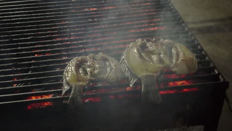 pescado a la parrilla en una parrilla de carbón rojo caliente