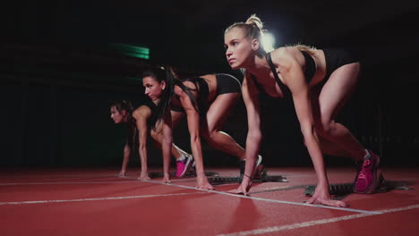 atletas femeninas calentándose en la pista de atletismo antes de una carrera. en cámara lenta