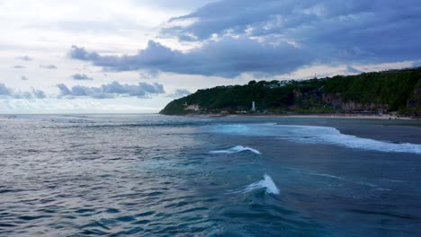 Flying-Above-Pandawa-Beach-With-Lighthouse-In-Bali,-Indonesia---drone-shot