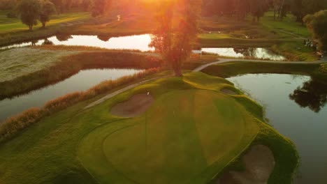 the last putting on the green by a golfer on the golf course during a sunny sunset