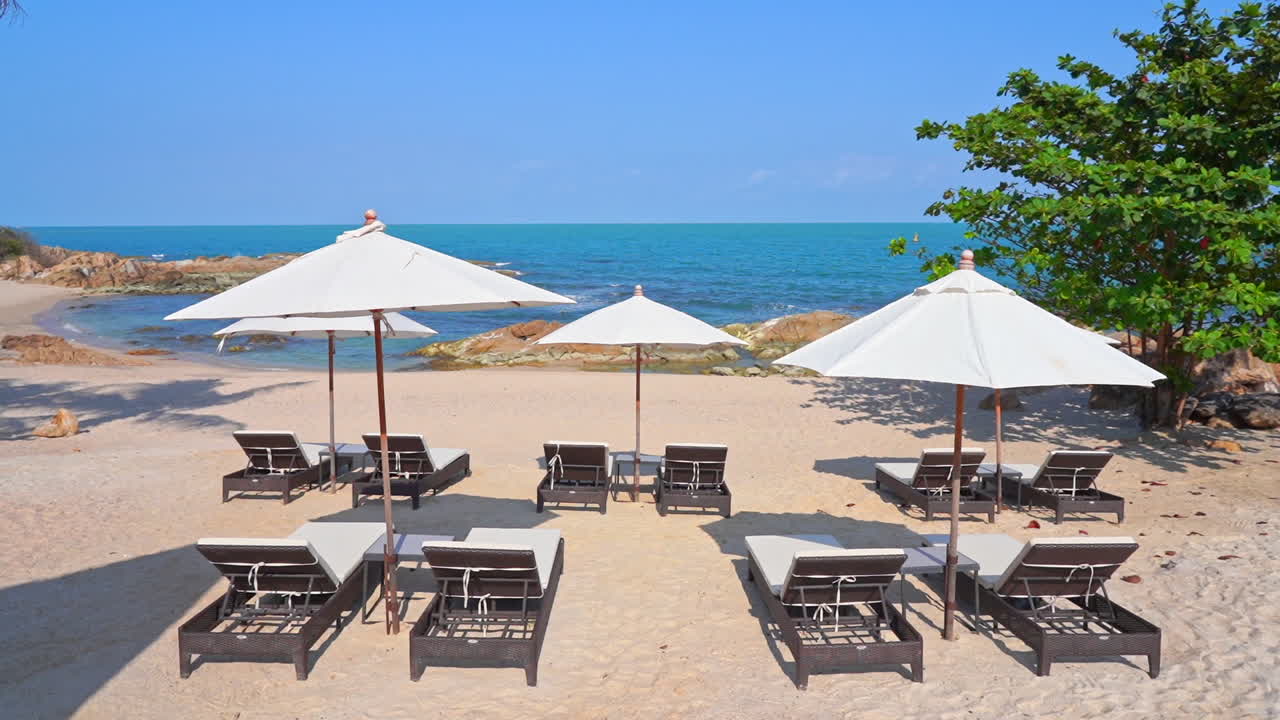 하얀 우산과 데크 의자가 있는 모래사장 해변 라운지