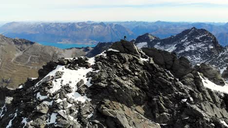hiker on a mountain peak with panoramic alpine views