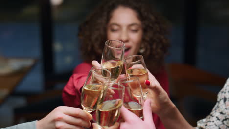 multiethnic friends make toast in restaurant. young people clinking drink glass.