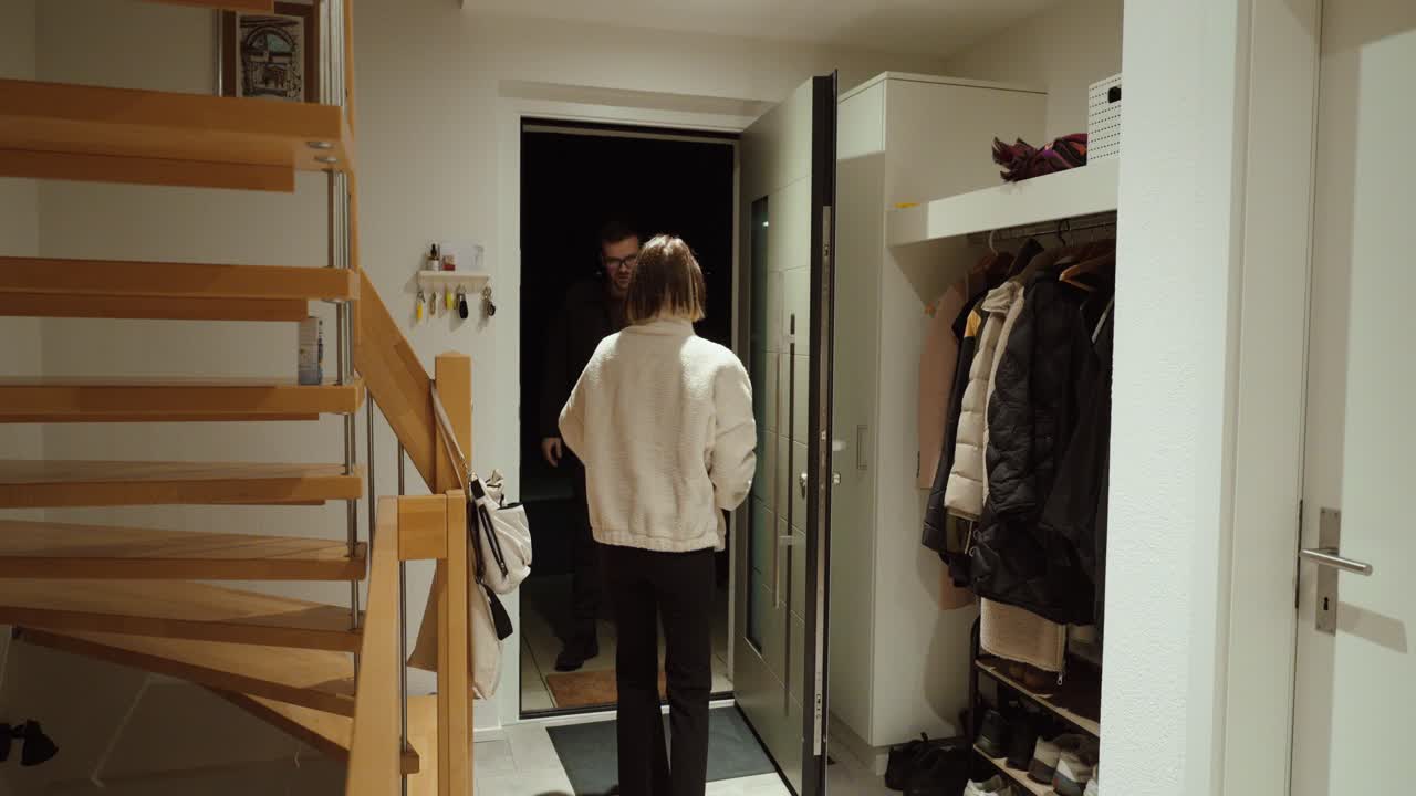 Donna che apre la porta d'ingresso e riceve una consegna di generi alimentari da un corriere, illustrando il servizio di consegna a domicilio, lo shopping online e la comodità quotidiana per il consumatore