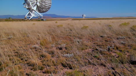 A-Tilt-Up-From-A-Windswept-Field-To-Distant-Satellite-Dishes