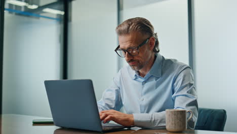 Überarbeiteter-Mann-Trinkt-Kaffee-Im-Büro-Am-Abend.-Geschäftsmann-Tippt-Laptop