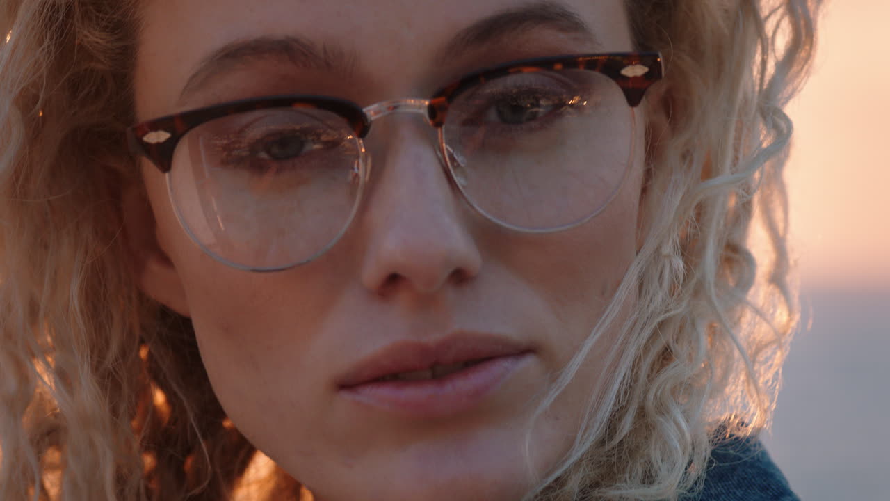 close up portrait of beautiful blonde woman looking confident enjoying relaxed vacation lifestyle feeling freedom on seaside at sunset