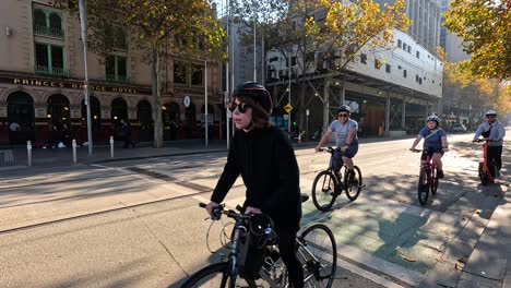 people riding bicycles and scooters on a street