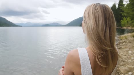 young blonde woman in white dress looking at the horizon