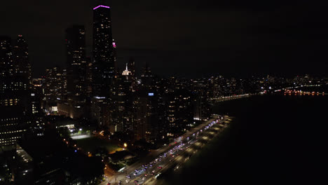 pan up reveals lake shore drive and hancock building at nighttime in chicago, il