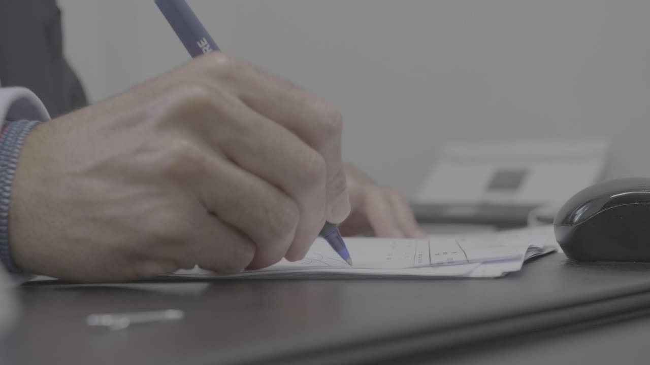 Hands of unrecognizable businessman signing agreement at meeting