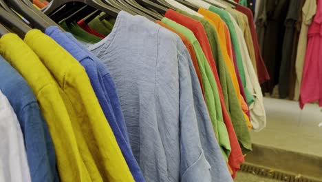camisas delgadas de colores coloridos y vestidos en colgadores para la venta en un mercado en el sol de francia