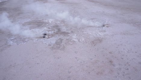 el tatio geysers steaming from the ground in the atacama desert in chile, south america