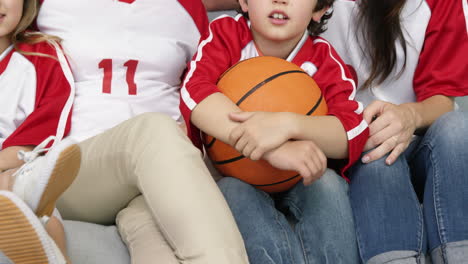 Familia-Sonriente-Con-Abuela-Viendo-Un-Partido-De-Baloncesto.