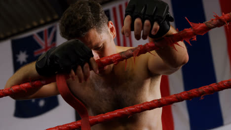 un boxeador cansado de pie en el ring