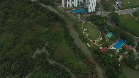 Drohnenschuss-Fliegt-über-Feuchtgebiete-Zu-Einem-Modernen-Hochhaus-Am-Stadtrand-Von-Ho-Chi-Minh-Stadt,-Vietnam,-Mit-Reisfeldern-Im-Hintergrund