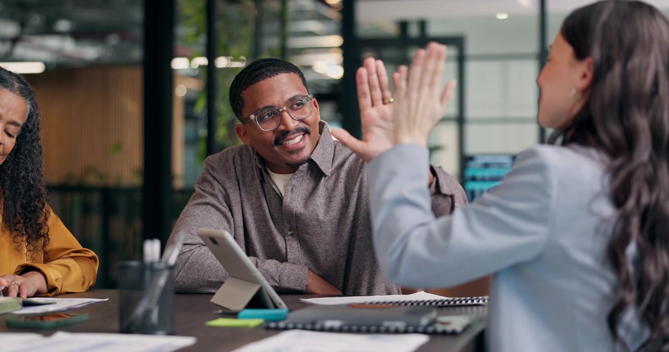 Diverse Business Team Celebrating Success with High Five in Office Meeting