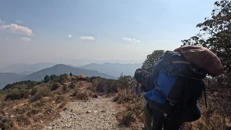 following 2 sherpas descending a mountain trail carrying heavy backpacks. nepal himalayan back country of kathmandu near chisapanis