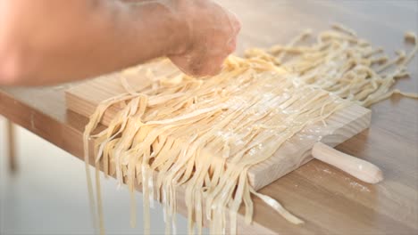 homemade pasta being prepared on wooden cutting board