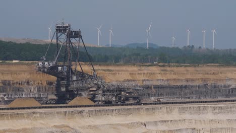 opencast lignite mine in the rhenish lignite mining area near düren in germany and windmills in background