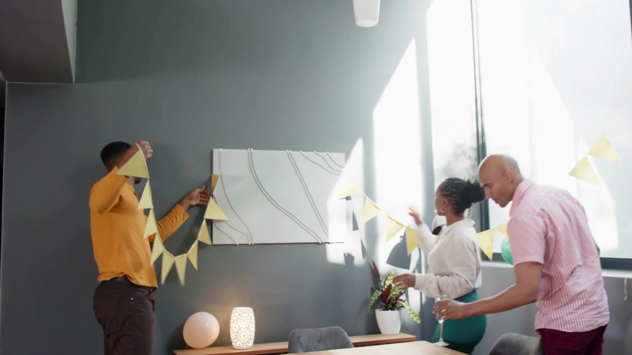Three hosts arriving with clap, hanging yellow bunting and aligning balloons for party