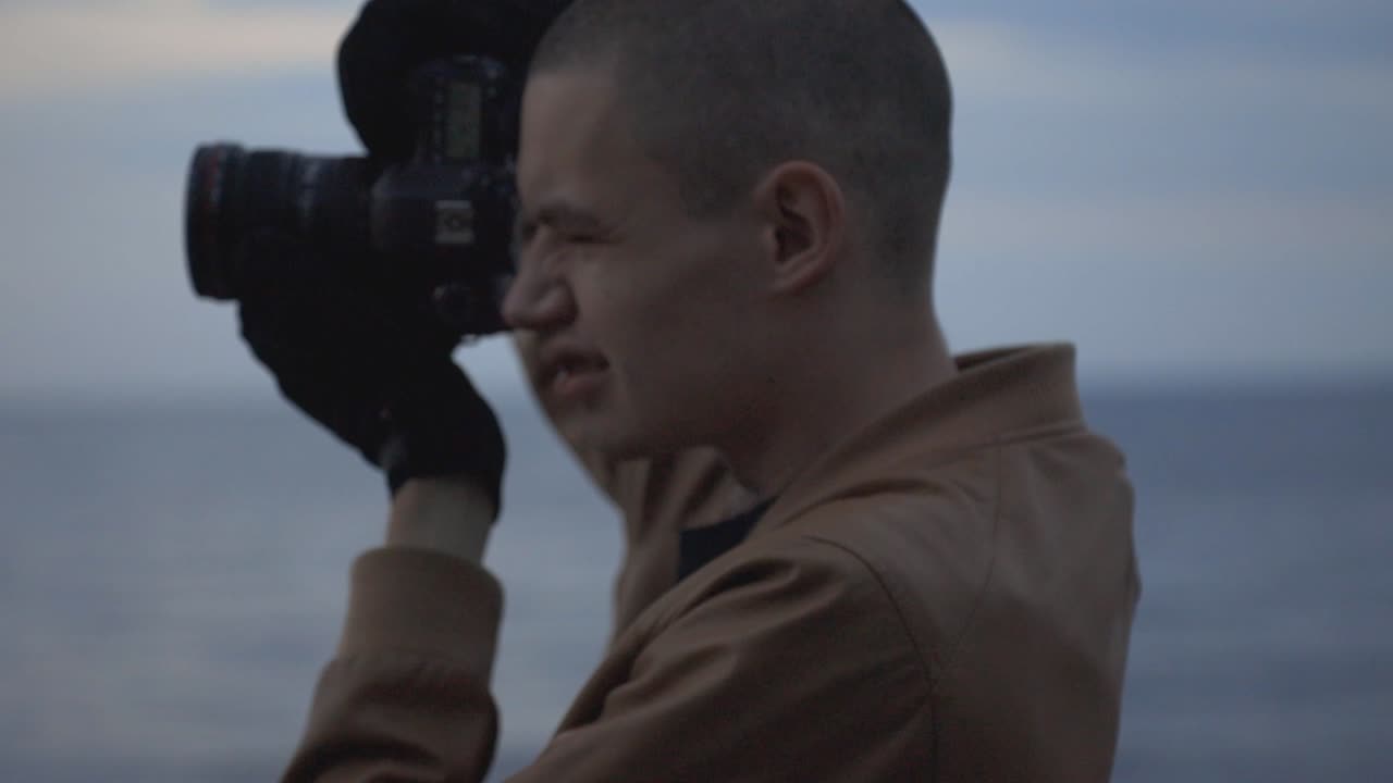Handsome Guy Holding A DSLR Camera Taking Photos At The Beach - Closeup Shot