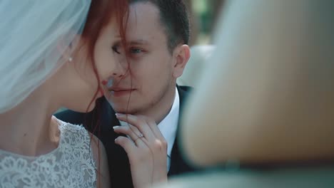 Newlyweds-sitting-car-convertible-look-at-each-other-interact-close-up