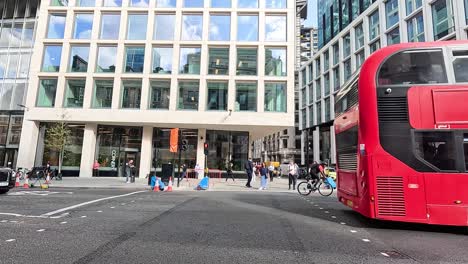 a red double-decker bus moves through london