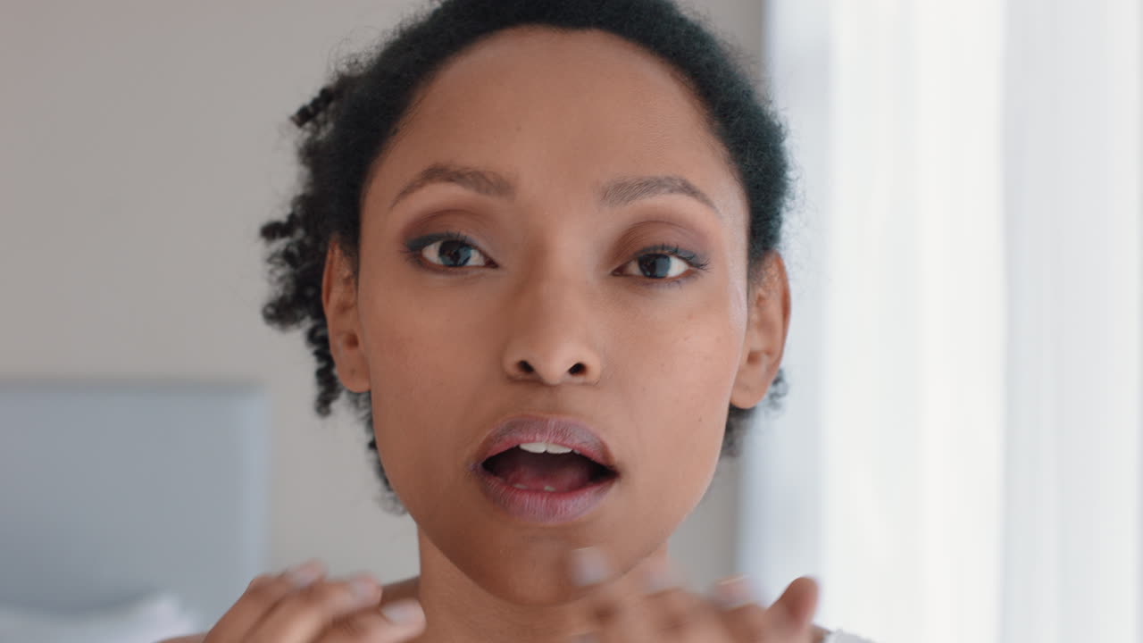 portrait beautiful african american woman looking in mirror at perfect skin enjoying natural complexion getting ready at home