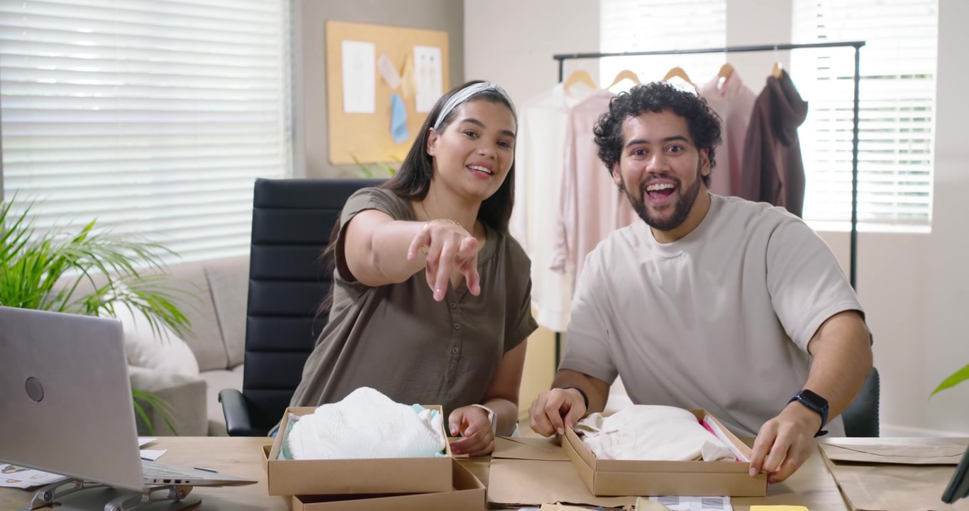 Socios afroamericanos recibiendo pedidos, abriendo cajas, inspeccionando camisas y preparando envíos