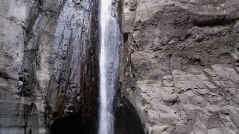 tilt down tamanique cascade waterfall into rock cliff grotto pool