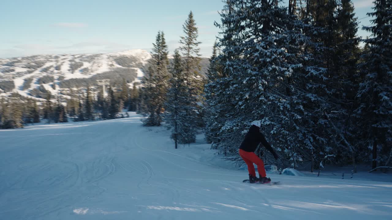 4k tracking of female snowboarder going downhill on a sunny winter day in Norway