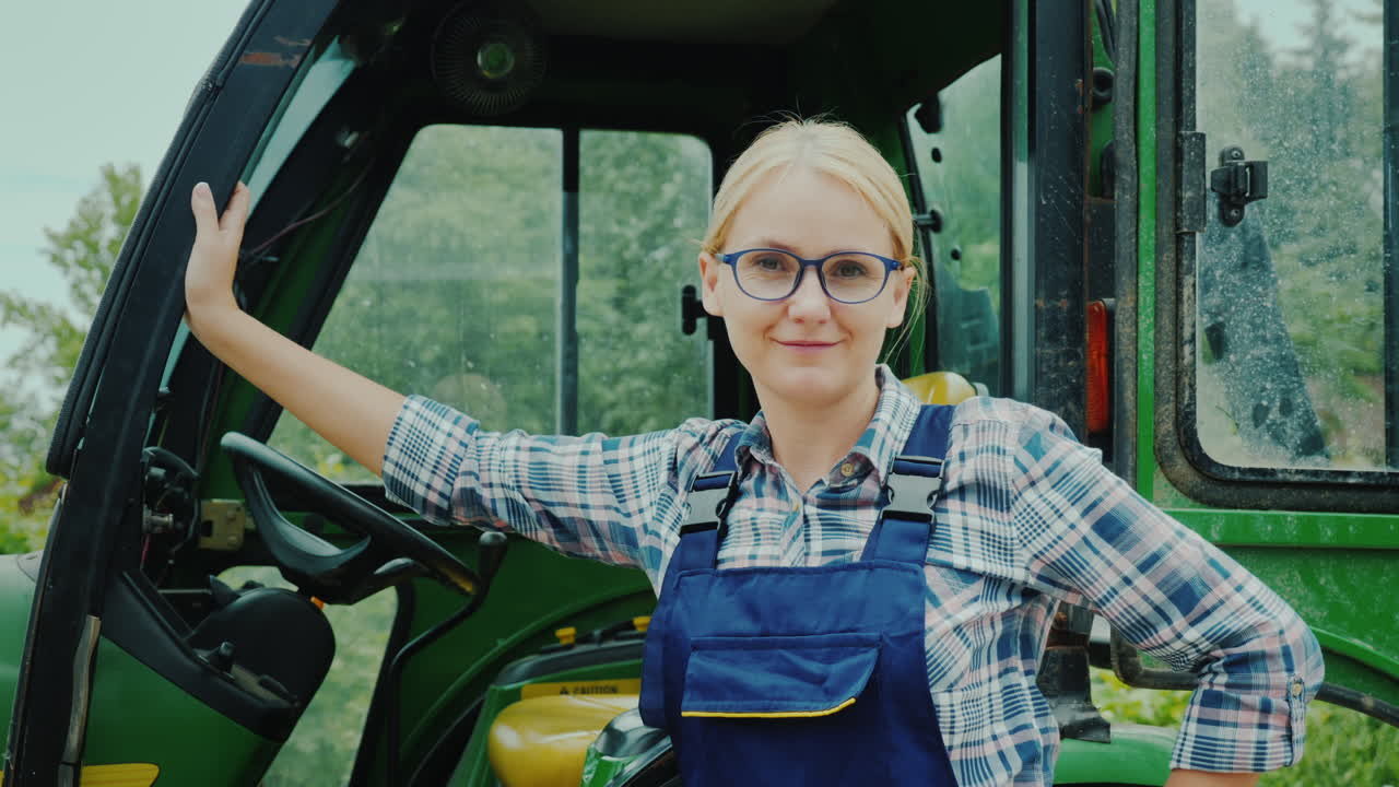 conductora de tractor de mujer confiada parada cerca de su tractor