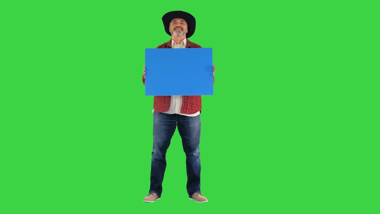 Fazendeiro idoso de chapéu segurando um cartaz em branco em Tela Verde, Chroma Key