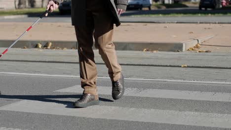 lone blind man detecting tactile tiles, walking to pedestrian crossing safe road