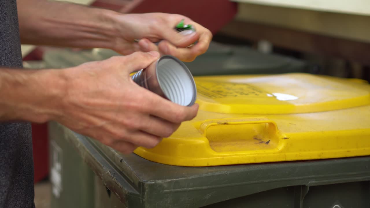 Premium stock video Person removes label from tin can, puts can in