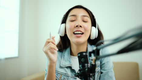 creadora de contenido mujer anfitriona transmitiendo su podcast en portátil con auriculares y micrófono entrevista animando conversación de invitados en el estudio de transmisión.
