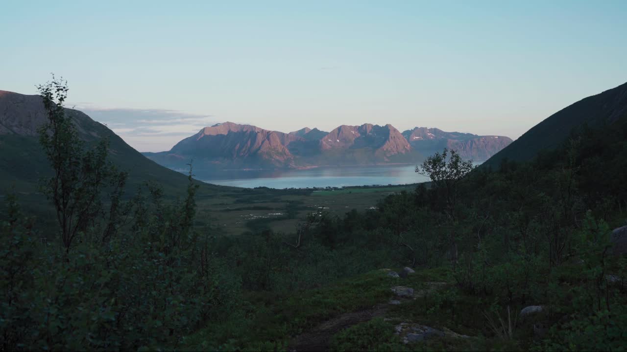 vista panorámica del fiordo entre las montañas durante la puesta de sol en flakstadvag, noruega