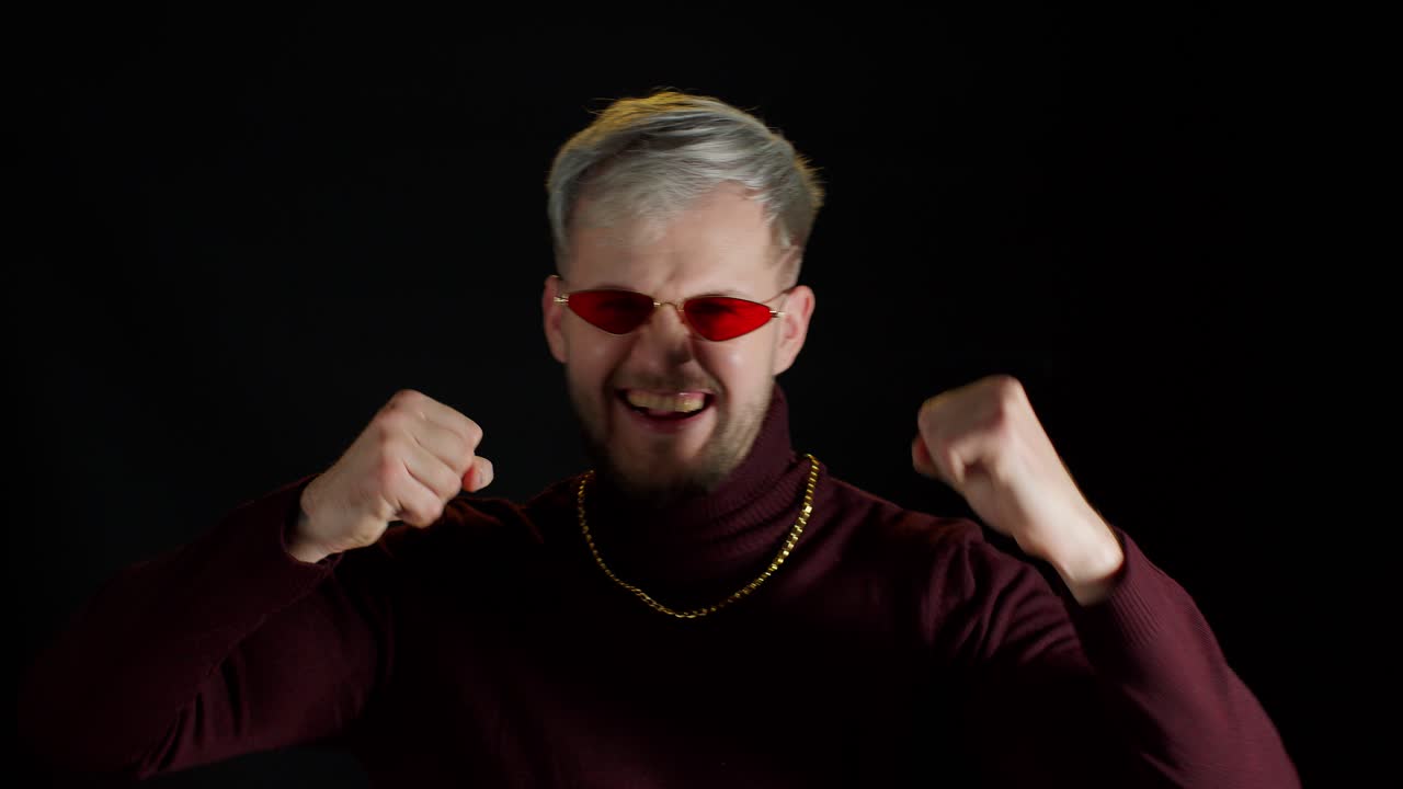 hombre gracioso elegante con gafas de sol rojas bailando haciendo tonterías divirtiéndose manos expresivas gesticulando