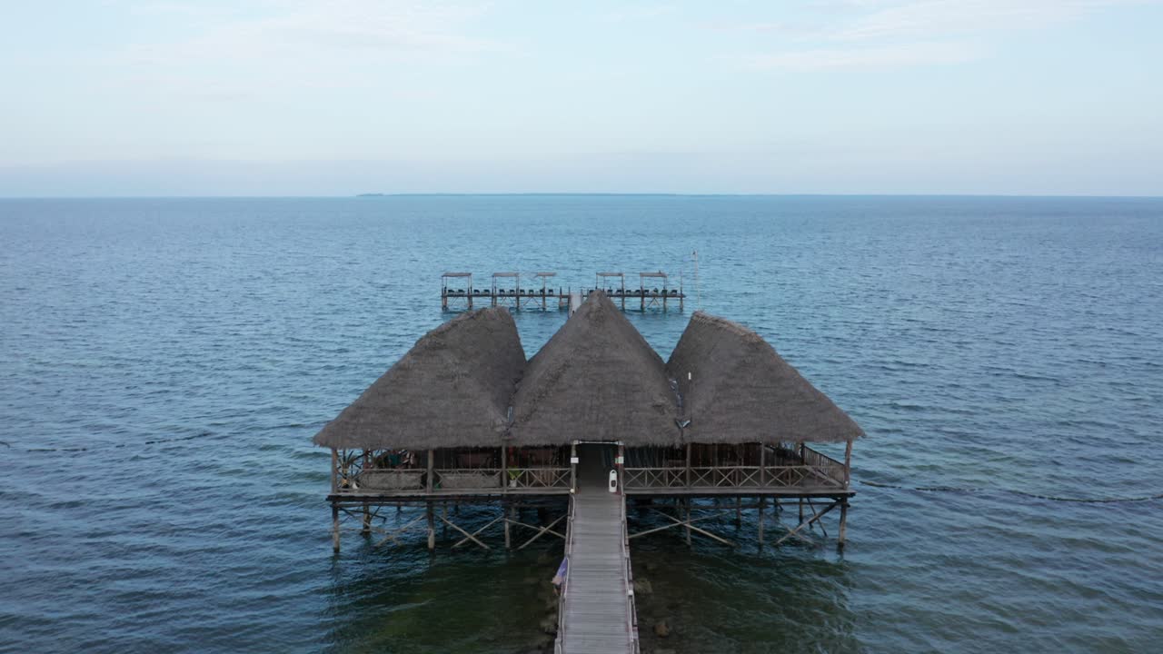 Aerial drone view flying foward over a pier in Zanzibar, Tanzania. Blue image.