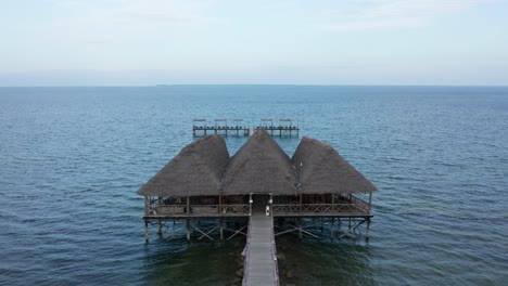 aerial drone view flying foward over a pier in zanzibar, tanzania. blue image.