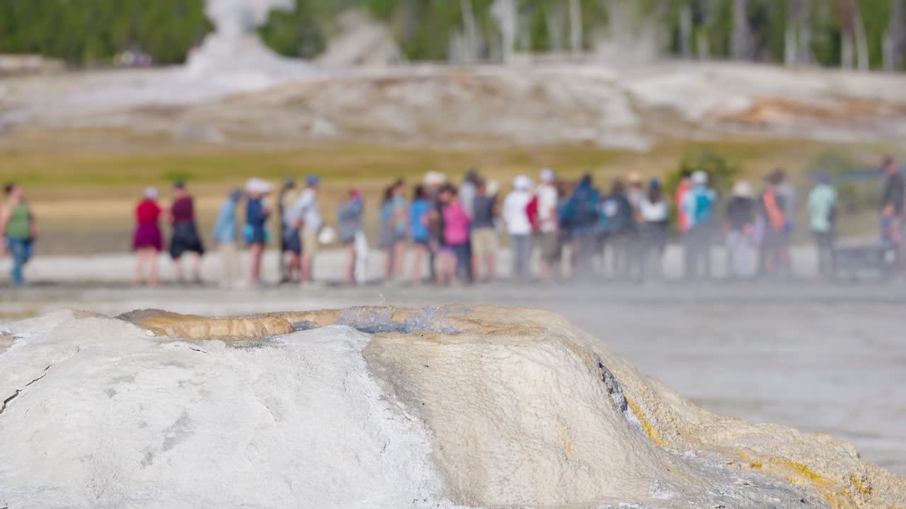 Small Geyser Erupting with Tourists in a National Park
