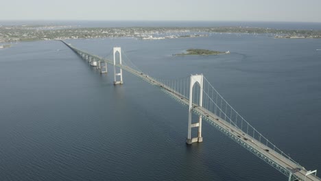 Drone-shot-of-a-big-bridge-that-crosses-the-water,-moving-forward-and-slowly-tilting-down