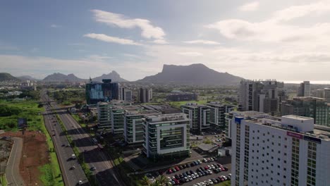 Ebene-cybercity-in-mauritius,-modern-buildings-with-mountain-backdrop,-sunny-day,-aerial-view