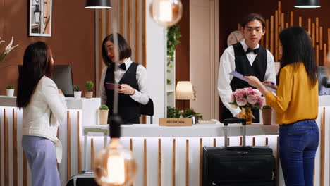 tourists going through check in process at hotel reception desk