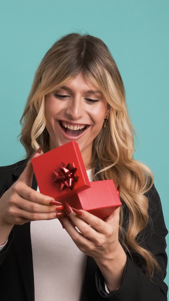 Excited transgender businesswoman opening small gift box