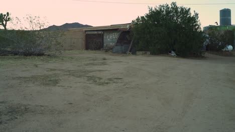 experience the allure of the open road in this cinematic clip captures as a lone adventurer arrives at an enchanting old farm in the heart of the desert, riding a vintage chopper motorcycle