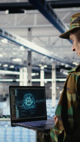 vertical video army programmer in high tech server hub uses ai application on laptop
