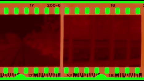 moving negative film strip on green backgrounc